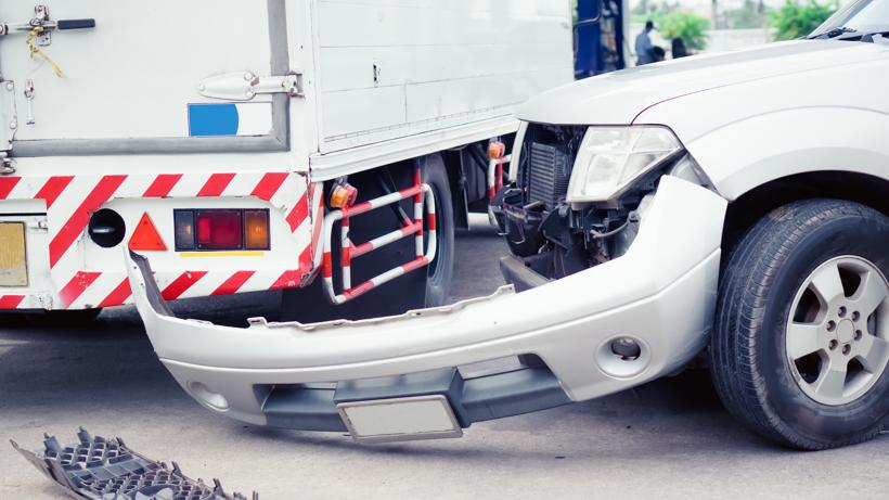 A car that had its front bumper knocked off in a truck accident.