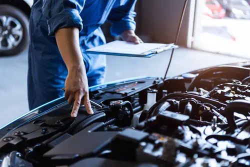 Legal Options For Defective Car Parts Causing Accidents Mechanic looking in car - defective car parts