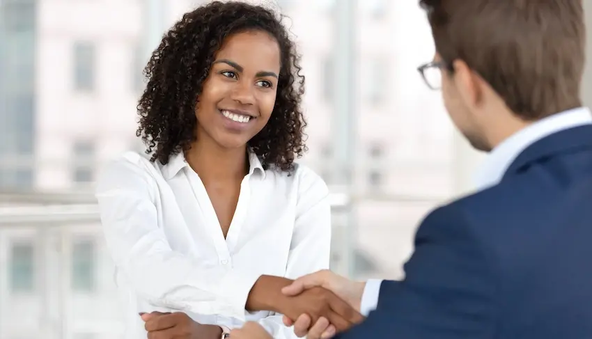 When Should You Hire a Lawyer After a Minor Fender Bender? A professional woman is shaking hands with an auto accident lawyer during a consultation meeting in a bright office setting in Georgia at the office of Wade Law.