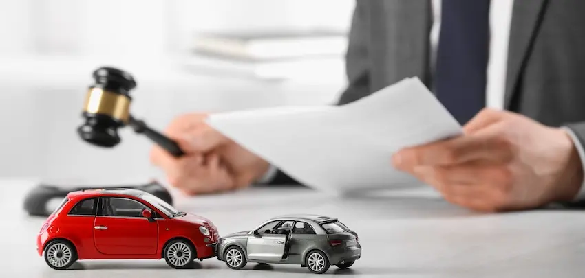 When Should You Hire a Lawyer After a Minor Fender Bender? A car accident attorney in Georgia is reviewing legal documents with a gavel and toy car collision models on the desk at Wade Law.