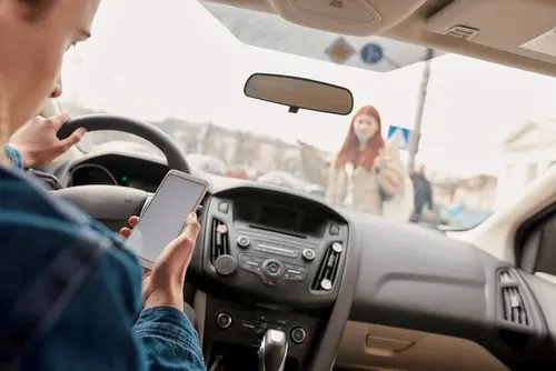 How to Prove the Other Driver Was Distracted at the Time of Your Crash Distracted driver looking at his phone running over a woman walking and this woman is looking to file a distracted driving accident claim
