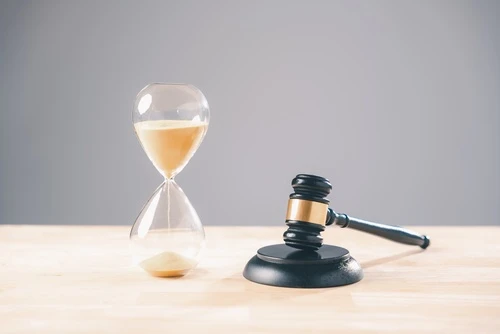 How Long Does It Take to Settle a Car Accident Case in Georgia? Judge’s gavel and hourglass represent how long it takes to settle a car accident case in Georgia