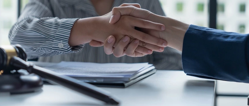 Atlanta Car Accident Lawyer A female car accident lawyer is shaking hands with a male client at Wade Law Office Injury Lawyer in Atlanta.