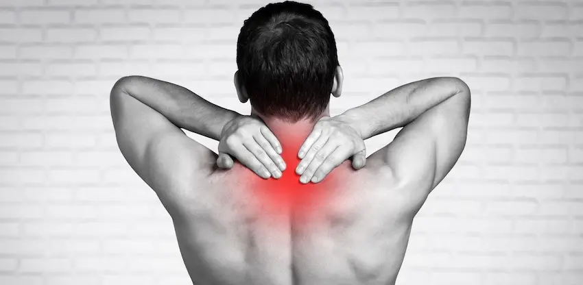 How Much Is Your Whiplash Injury Really Worth? A black and white rear view of a shirtless man pressing both hands against the base of his neck and upper back with a red highlight overlay pinpointing the exact area of pain representing the chronic and debilitating soreness at the neck and shoulder junction that is the hallmark symptom of a whiplash injury in Georgia.