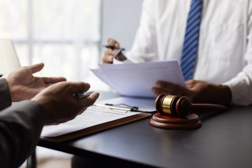 Atlanta Personal Injury Lawyer A personal injury lawyer reviewing legal documents of a personal injury case while sitting across from a client.